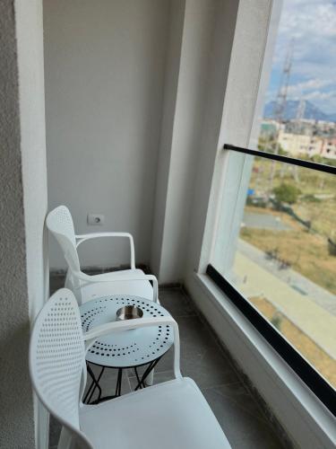 a room with two chairs and a table and a window at Shehu Apartments in Tirana