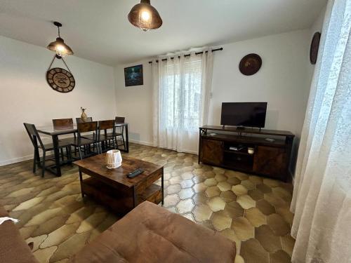 ein Wohnzimmer mit Sofa und Tisch in der Unterkunft Maison calme avec jardin & terrasses 