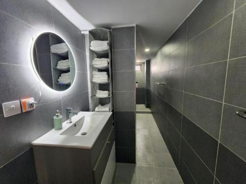 un baño con lavabo y espejo en Azuria Horizon Beach Apartment, en Flic en Flac