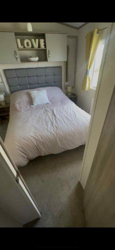 a small bedroom with a bed with white sheets at 149 Northfield in Ulrome