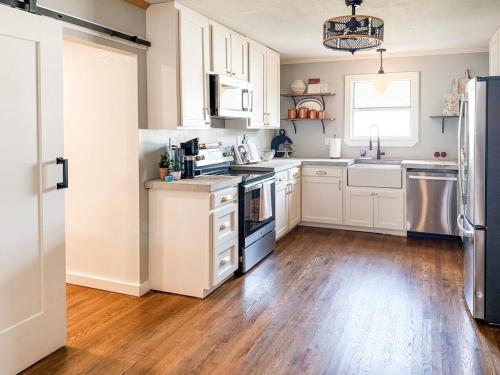 une cuisine avec des armoires blanches et un plancher en bois dans l'établissement Heritage House, à Brady