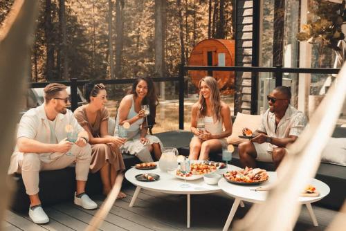 a group of people sitting on a deck eating food at Zen House 4 - Villas & Spa in Morin Heights