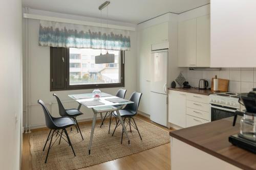 a kitchen with a table and chairs in a kitchen at One-bedroom apartment with free parking in Oulu