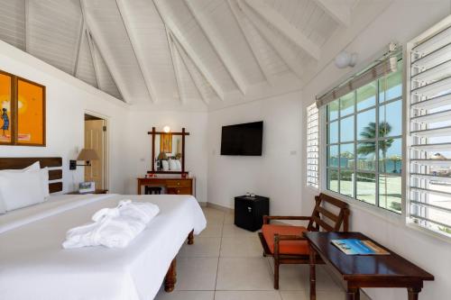 a bedroom with a bed and a table and a tv at Grand Muthu Runaway Bay Club Caribbean in Runaway Bay
