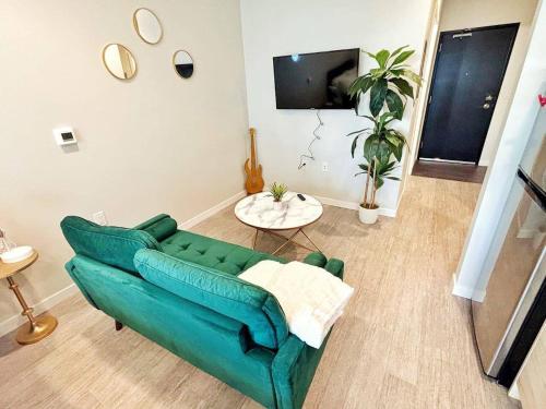 a living room with a green couch and a table at Tranquil Escape in Des Moines