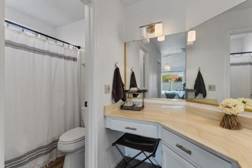 a bathroom with a sink and a toilet and a mirror at Stadium Retreat 3Br Pool, Games, Relaxing Oasis in Glendale
