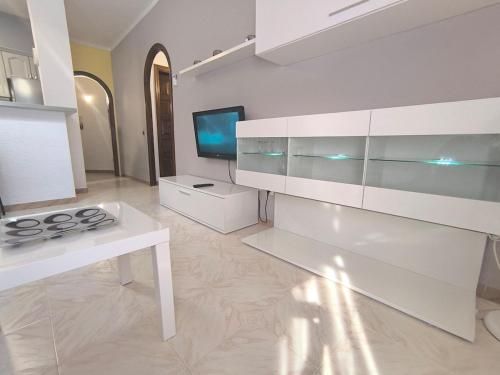 cocina blanca con fogones y TV en Rincón en el centro de Palamós, en Palamós