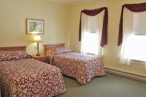a hotel room with two beds and two windows at Silver Bay YMCA Inn and Conference Center in Silver Bay