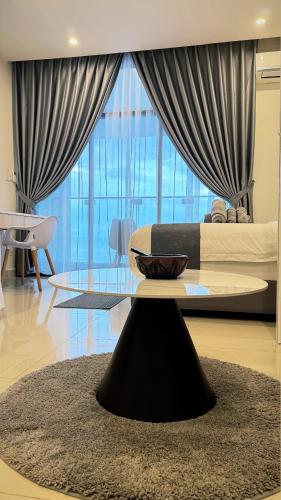 a living room with a table and a large window at The Shore Kota Kinabalu by Ems Executive Suites Seaview in Kota Kinabalu