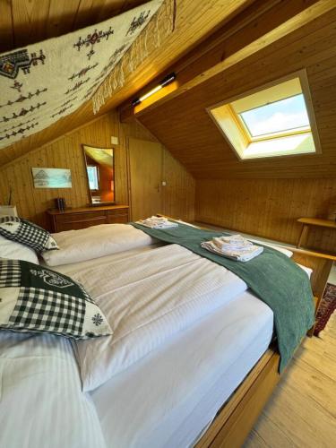 a bedroom with two beds in a wooden cabin at Historic Lakeview Swiss Chalet near Interlaken in Niederried