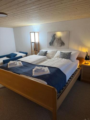 a bedroom with a large bed with towels on it at Historic Lakeview Swiss Chalet near Interlaken in Niederried