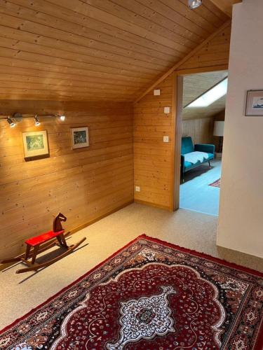 a living room with a red bench and a rug at Historic Lakeview Swiss Chalet near Interlaken in Niederried