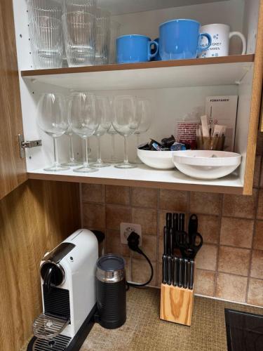 a kitchen counter with wine glasses and a toaster at Historic Lakeview Swiss Chalet near Interlaken in Niederried