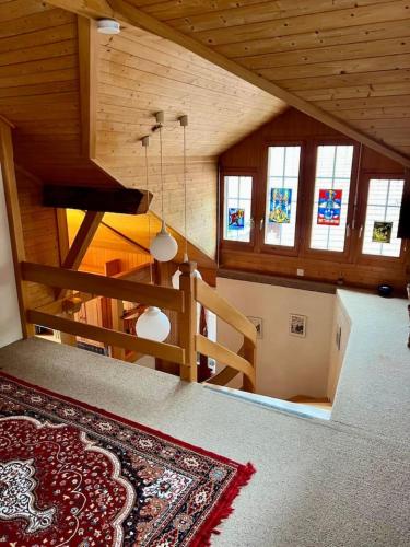 an attic room with a staircase with windows and a rug at Historic Lakeview Swiss Chalet near Interlaken in Niederried