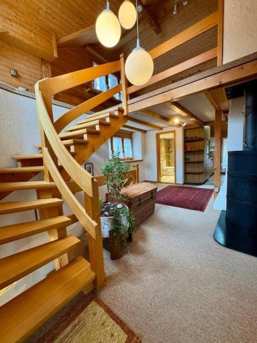 a spiral staircase in a room with wooden ceilings at Historic Lakeview Swiss Chalet near Interlaken in Niederried