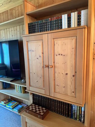 a book shelf with wooden cabinets and books at Historic Lakeview Swiss Chalet near Interlaken in Niederried