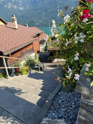 a house with a pathway and flowers in front of it at Historic Lakeview Swiss Chalet near Interlaken in Niederried