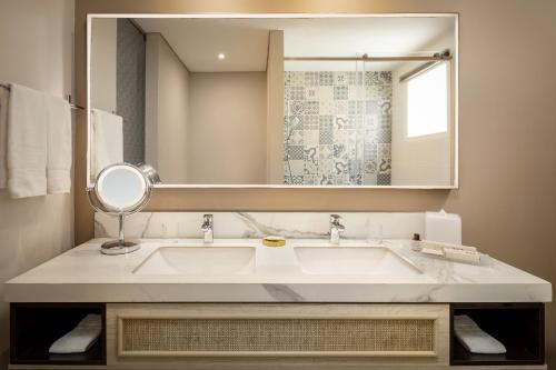 a bathroom with a sink and a mirror at Ermita Cartagena, a Tribute Portfolio Hotel in Cartagena de Indias