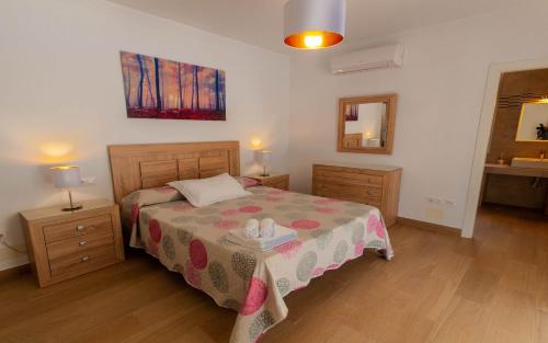 a bedroom with a bed with a table and a mirror at Villa 294 by Villamya in El Gastor