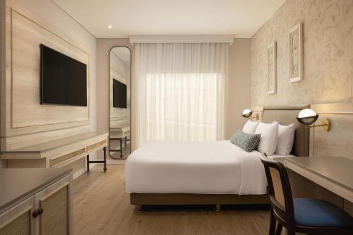 a hotel room with a bed and a television at Ermita Cartagena, a Tribute Portfolio Hotel in Cartagena de Indias