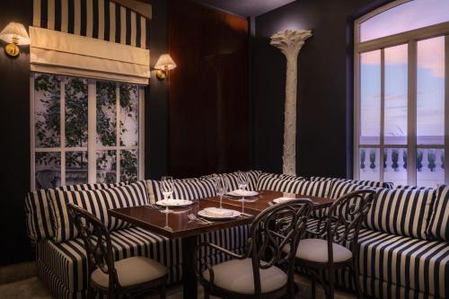 a restaurant with a striped couch and tables and chairs at Ermita Cartagena, a Tribute Portfolio Hotel in Cartagena de Indias