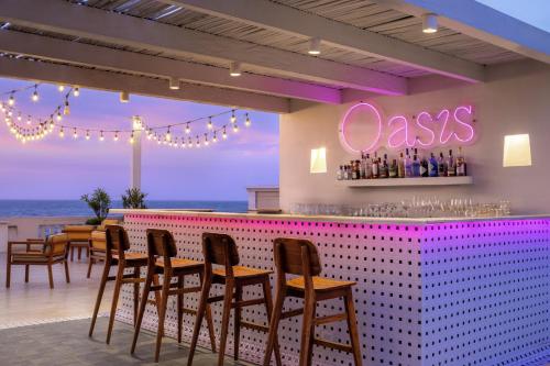 a restaurant with a bar with chairs and a pink counter at Ermita Cartagena, a Tribute Portfolio Hotel in Cartagena de Indias