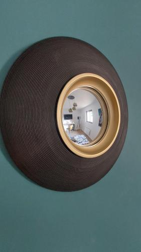 a mirror hanging on a wall with a room at Résidence Tamaris Paloma in Plouër-sur-Rance