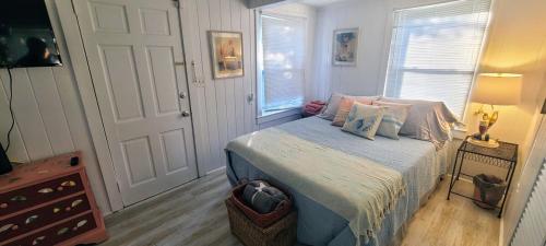 a bedroom with a bed with pillows on it at Crescent Vintage Cottage in Myrtle Beach