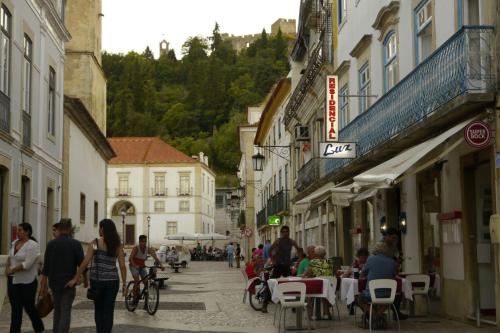a group of people walking down a street with buildings at Residencial Luz in Tomar