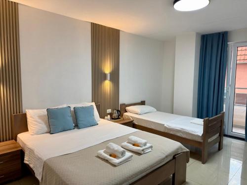 two beds in a hotel room with towels on them at Hotel Majestic in Struga