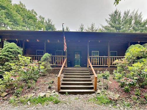 a house with stairs leading to a porch with an american flag at Wander Through the Woods in McHenry