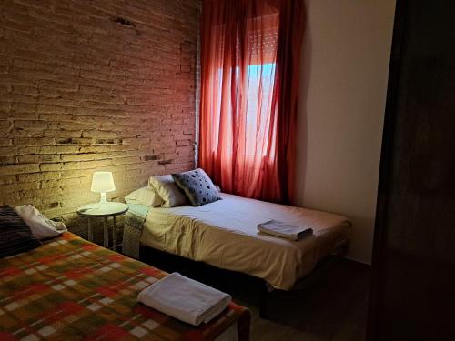 a bedroom with two beds and a brick wall at Barça Barcelona, Mia in Hospitalet de Llobregat