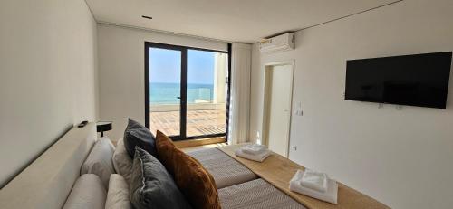a living room with a couch and a flat screen tv at Casa de Luxo na Praia de Ofir in Fão