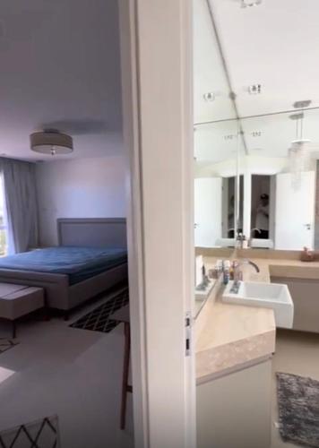 a bathroom with a bed and a sink in a room at Búzios Mansion Canal Area in Búzios