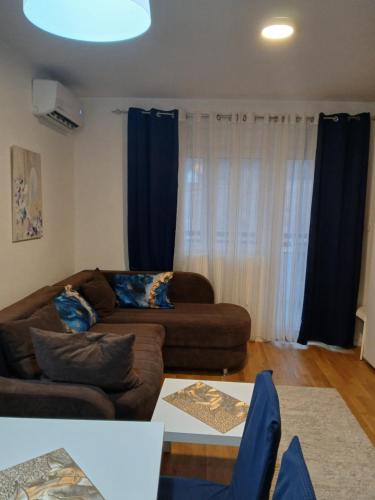 a living room with a couch and blue curtains at Apartman s parkingom, blizu Akva parka, Natura Lux - Green Hill, Sokobanja in Soko Banja