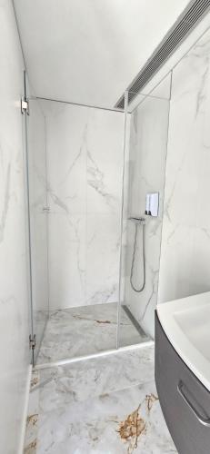 a shower with a glass door and a sink in a bathroom at Casa de Luxo na Praia de Ofir in Fão