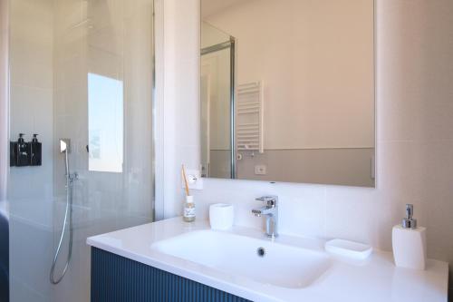 a white bathroom with a sink and a shower at Casa Bea & Gin - Via Giacomo Matteotti 2A in Sassari