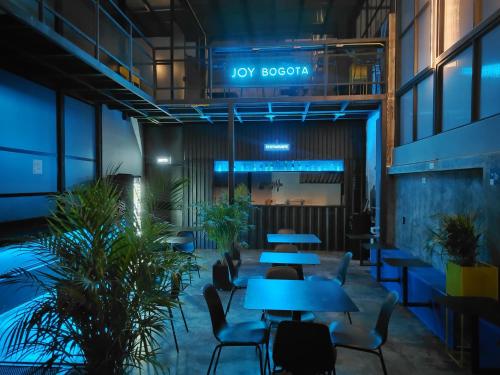 a lobby with tables and chairs and plants at Hostel Joy Calle 85 in Bogotá