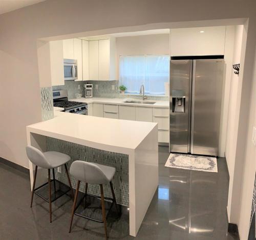 Una cocina con encimera blanca y refrigerador. en The Artisan - A Modern Mid-Century Chalet, en Hollywood