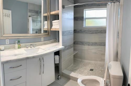 Un baño con lavabo, inodoro y ducha. en The Artisan - A Modern Mid-Century Chalet, en Hollywood