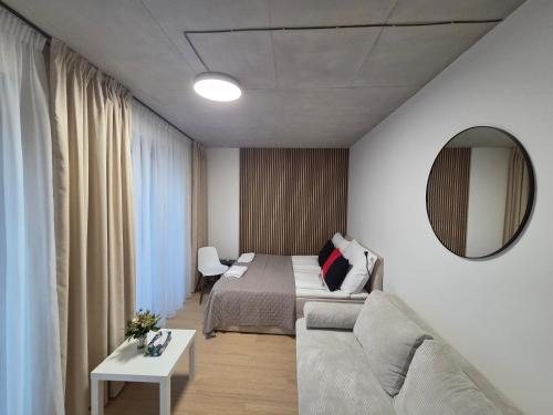 a bedroom with a bed and a mirror and a couch at Haas Apartments Art with parking, bakery, coffea in Brno