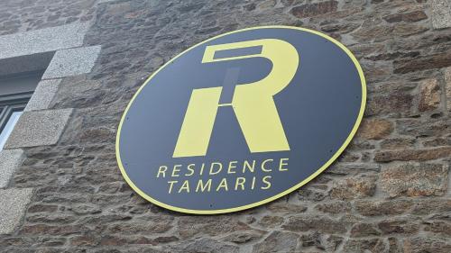 a sign on the side of a brick building at Résidence Tamaris Paloma in Plouër-sur-Rance