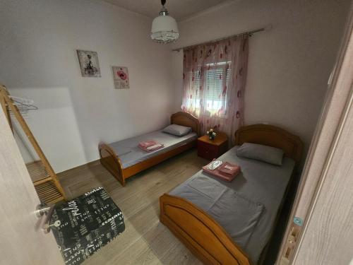 a small room with two beds and a window at Chrysalis House in Nea Potidaea