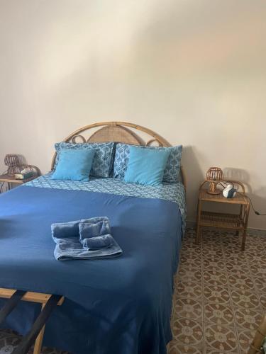 a bed with blue sheets and blue pillows on it at Casa al mare in Scauri
