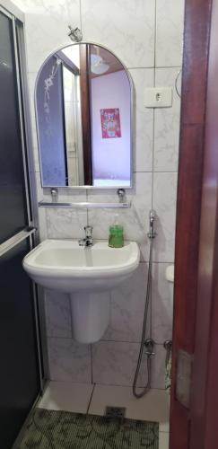une salle de bain avec un lavabo et un miroir dans l'établissement Pousada Conquista do Paraíso, à Alto Paraíso de Goiás