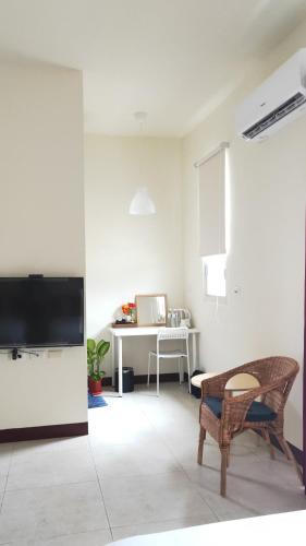 a living room with a television and a desk at 響樂池上電梯民宿1663 Chishang Music Guesthouse in Chishang