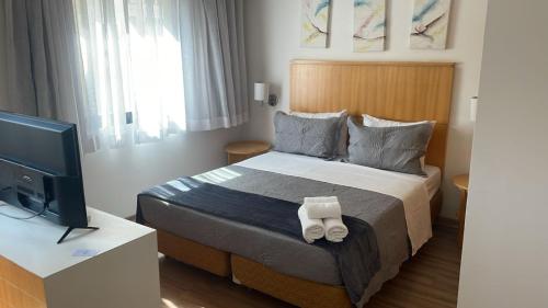 a hotel room with a bed and a television at Hotel Mercu Privi Moema Ibirapuera com ar e piscina 1810 in Sao Paulo