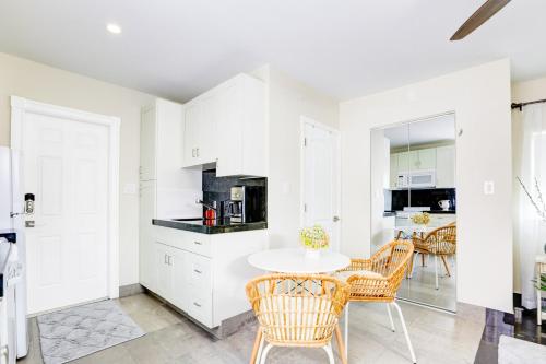 Una cocina con gabinetes blancos y una mesa y sillas. en La Moderna - A Private Guesthouse, en Hollywood