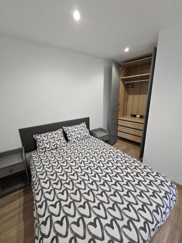 a bedroom with a black and white bed and a closet at Confort House in Argentona