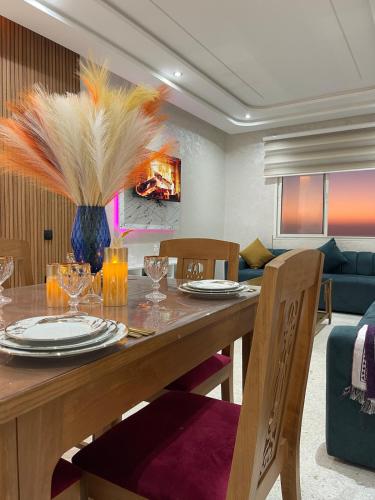 a dining room with a table with chairs and a couch at Sunset Vibes Larache in Larache